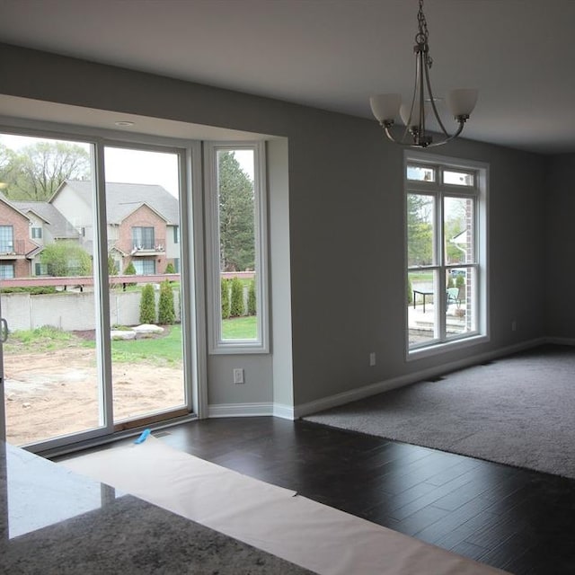 doorway featuring dark hardwood / wood-style flooring, an inviting chandelier, and a healthy amount of sunlight