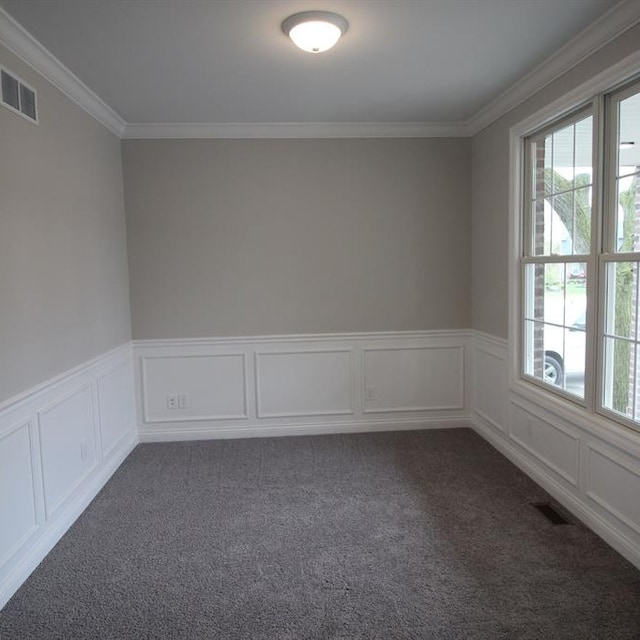 empty room with crown molding and dark carpet