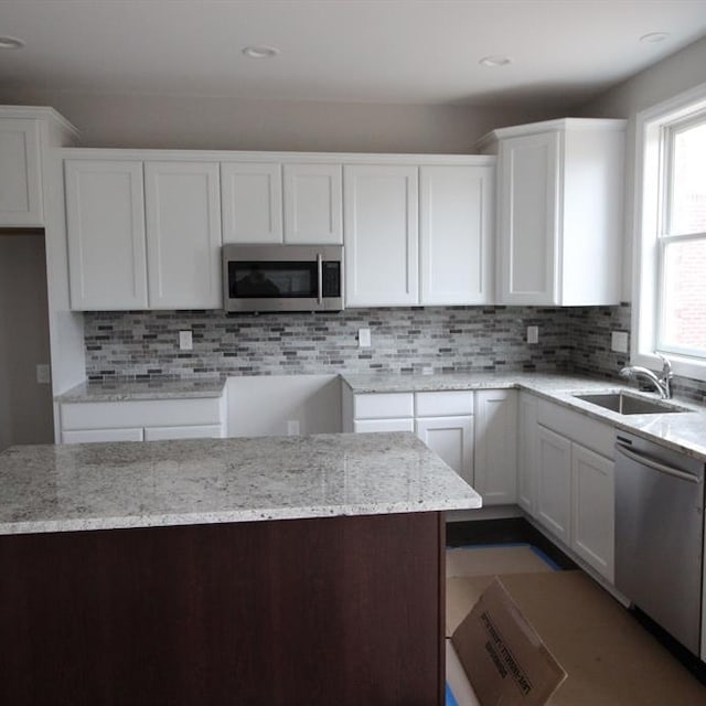 kitchen featuring appliances with stainless steel finishes, white cabinetry, and plenty of natural light