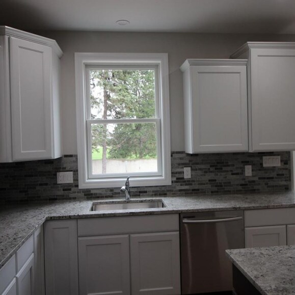 33690 N Bostwick, Farmington Hills, MI 48335 - kitchen with dishwasher, a sink, white cabinets, and backsplash