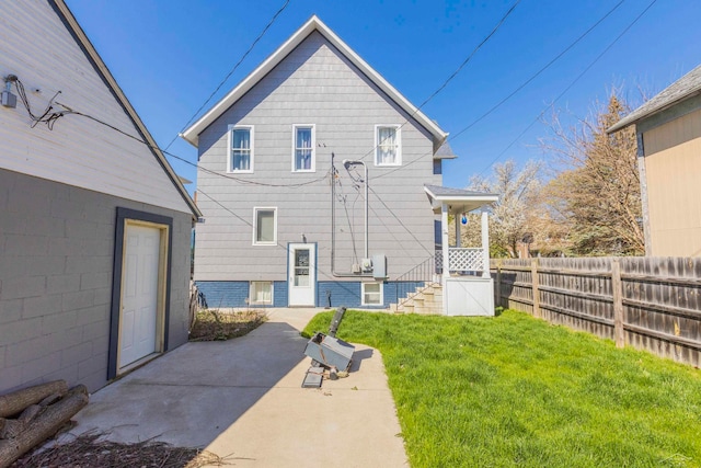 rear view of property featuring a lawn and a patio