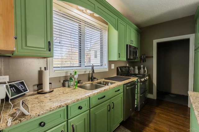 kitchen with appliances with stainless steel finishes, a textured ceiling, sink, dark hardwood / wood-style floors, and green cabinets