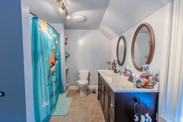 bathroom with rail lighting, tile patterned floors, vaulted ceiling, toilet, and vanity