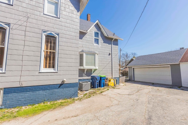 view of side of property with cooling unit and a garage