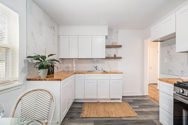 kitchen with gas stove, sink, dark hardwood / wood-style floors, white cabinetry, and butcher block counters