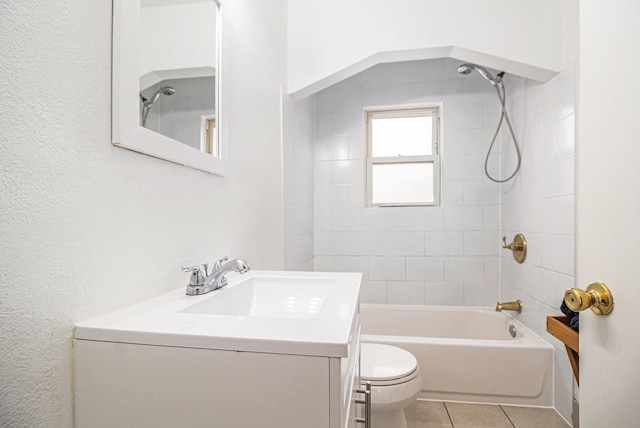 full bathroom featuring tile patterned flooring, tiled shower / bath combo, toilet, and vanity