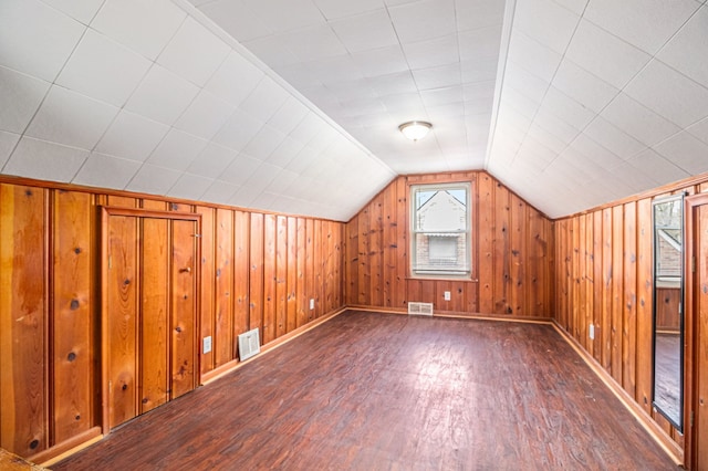 bonus room with wood walls, dark hardwood / wood-style flooring, and lofted ceiling