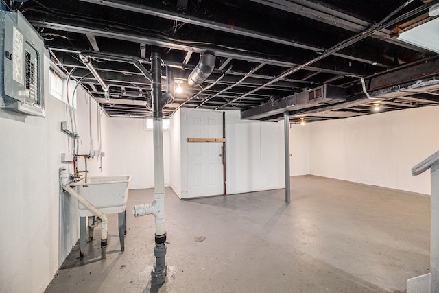 basement featuring electric panel and sink