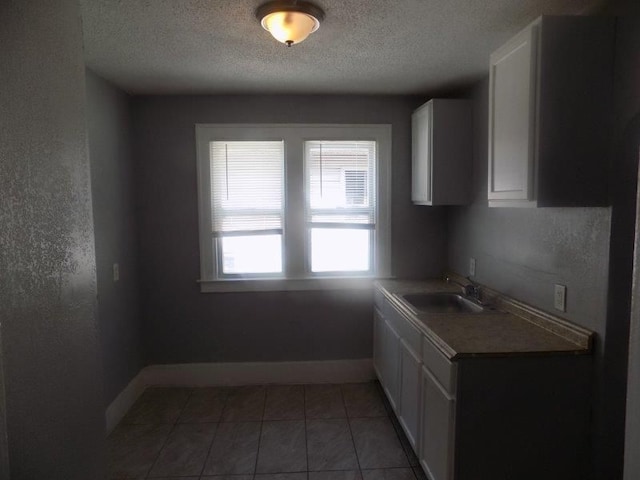 6334 Tuxedo Ave, Detroit, MI 48204 - kitchen featuring a sink, a textured ceiling, white cabinets, baseboards, and light countertops