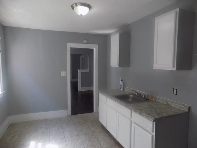 kitchen featuring white cabinets, a textured ceiling, and sink