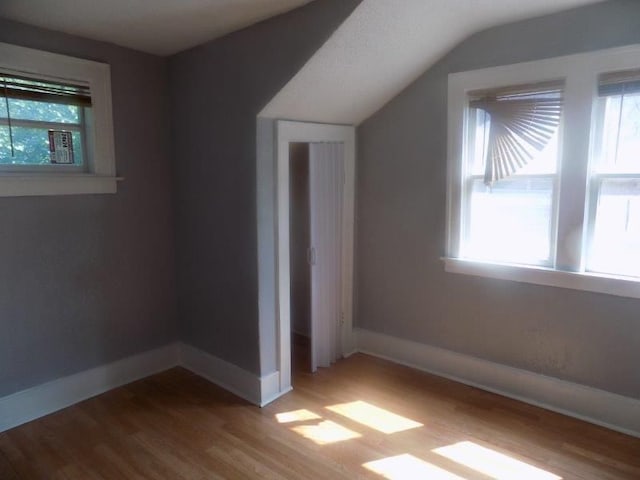 bonus room featuring a healthy amount of sunlight, vaulted ceiling, and light hardwood / wood-style floors