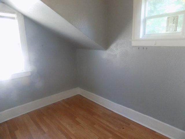 additional living space featuring hardwood / wood-style flooring and lofted ceiling