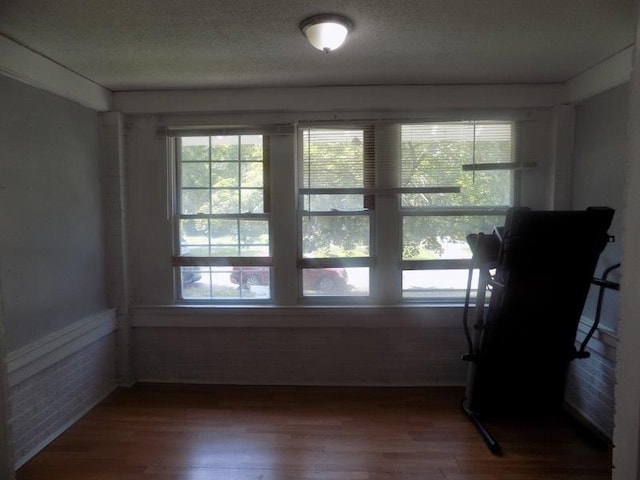 unfurnished room with hardwood / wood-style floors and a textured ceiling