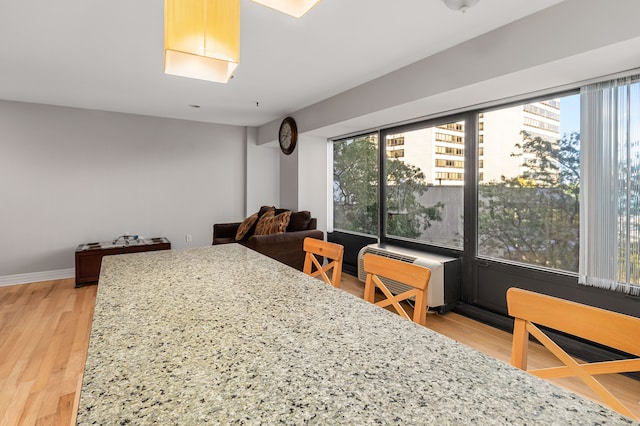 dining area with hardwood / wood-style flooring and an AC wall unit