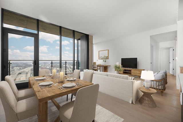 dining space featuring floor to ceiling windows and light wood-type flooring