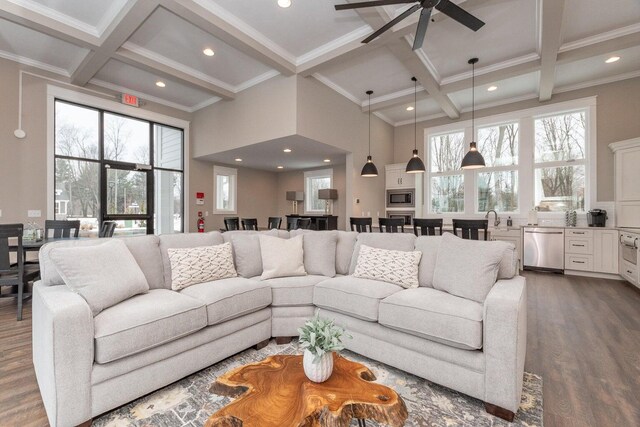 living room featuring hardwood / wood-style flooring, plenty of natural light, coffered ceiling, and beamed ceiling