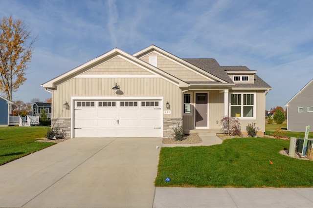 craftsman inspired home with a garage and a front lawn