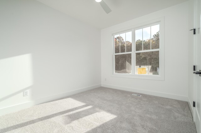 unfurnished room featuring ceiling fan and carpet