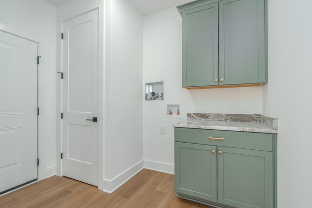 washroom featuring cabinets, washer hookup, and light hardwood / wood-style floors