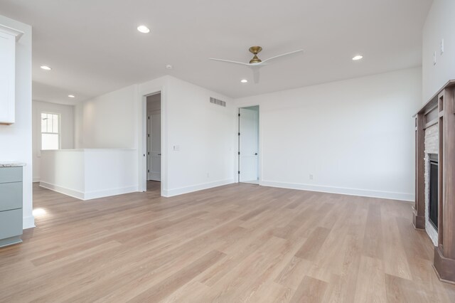 unfurnished living room featuring ceiling fan and light wood-type flooring