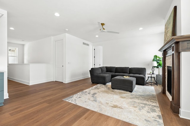 living room with dark hardwood / wood-style flooring and ceiling fan