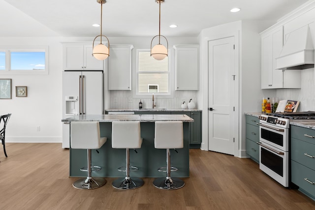 kitchen with white cabinetry, sink, pendant lighting, and white appliances