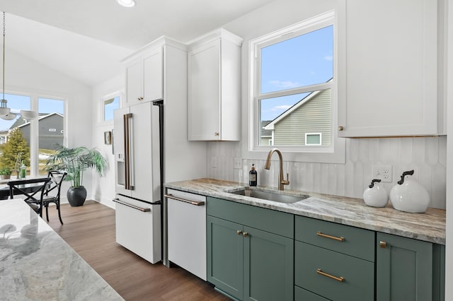 kitchen with sink, wood-type flooring, green cabinets, white appliances, and white cabinets