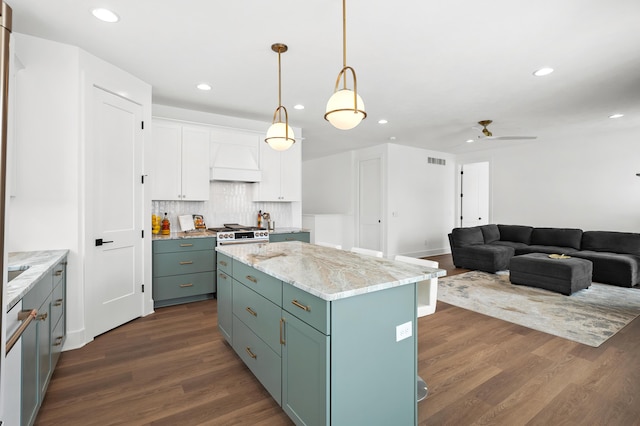 kitchen with a kitchen island, dark hardwood / wood-style floors, white cabinets, decorative backsplash, and hanging light fixtures