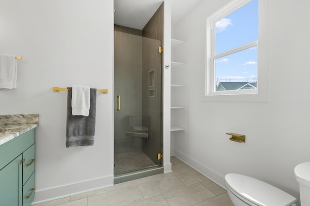 bathroom with vanity, a shower with shower door, tile patterned floors, and toilet