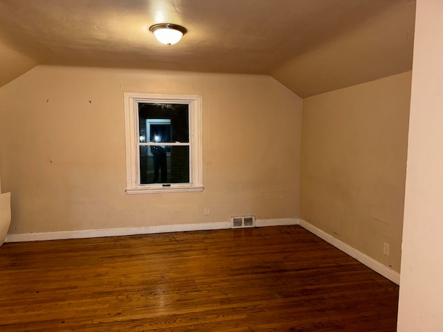 additional living space with dark hardwood / wood-style floors and vaulted ceiling