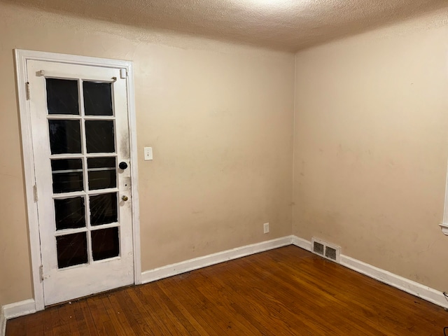 empty room featuring hardwood / wood-style floors and a textured ceiling