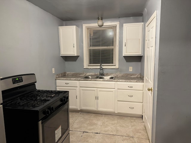 kitchen with white cabinets, light tile patterned floors, sink, and stainless steel range with gas stovetop