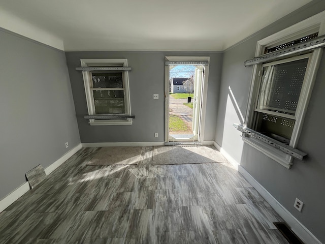 interior space with dark hardwood / wood-style flooring and ornamental molding