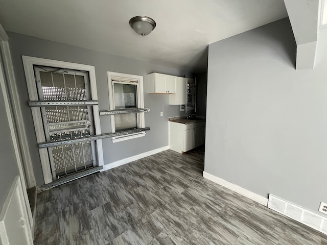 interior space with white cabinetry and dark wood-type flooring