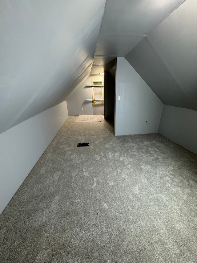 bonus room with carpet floors and vaulted ceiling