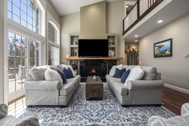 3975 Harbor Breeze Dr, Norton Shores, MI 49441 - living room with baseboards, wood finished floors, a high ceiling, a fireplace, and recessed lighting