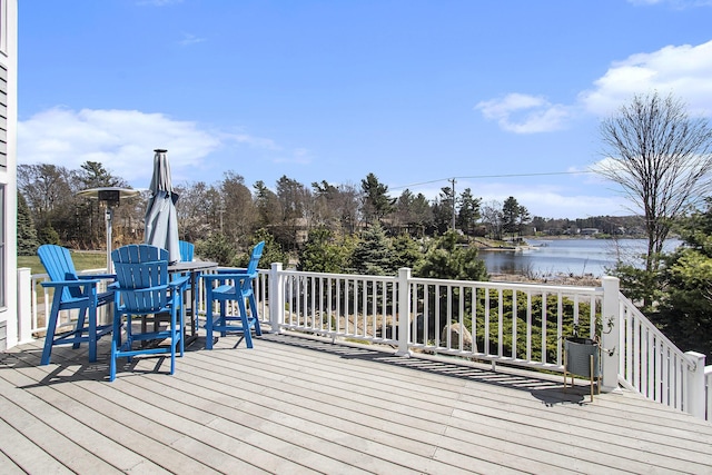 3975 Harbor Breeze Dr, Norton Shores, MI 49441 - wooden terrace featuring a water view, outdoor dining space, and view of wooded area