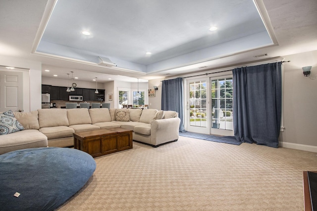 3975 Harbor Breeze Dr, Norton Shores, MI 49441 - living area featuring a tray ceiling, light colored carpet, recessed lighting, and baseboards