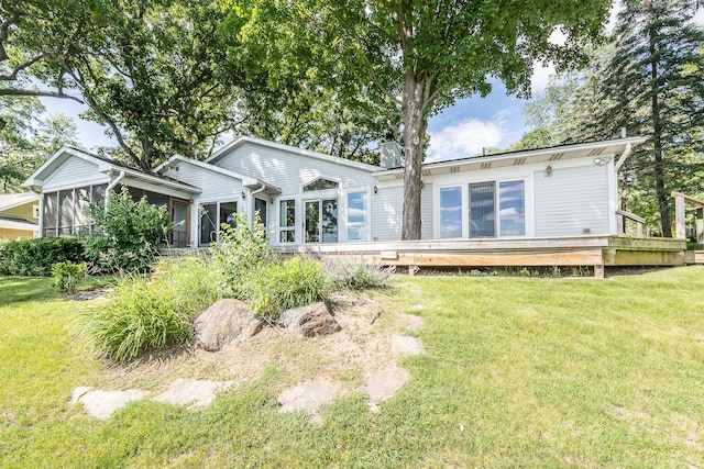 back of house with a sunroom, a deck, and a yard