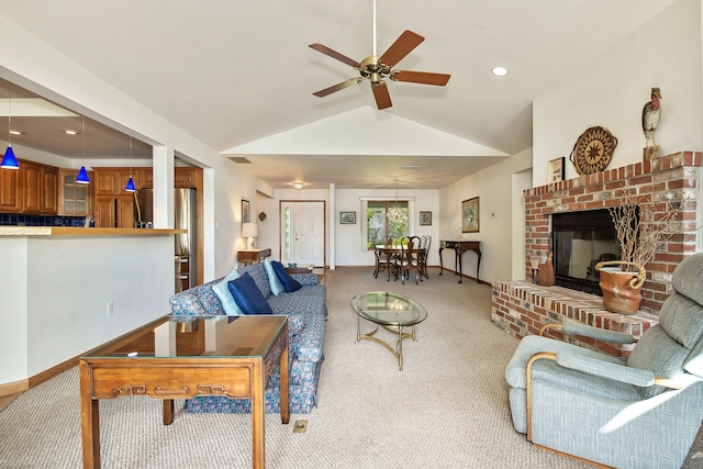 carpeted living room featuring ceiling fan, lofted ceiling, and a brick fireplace