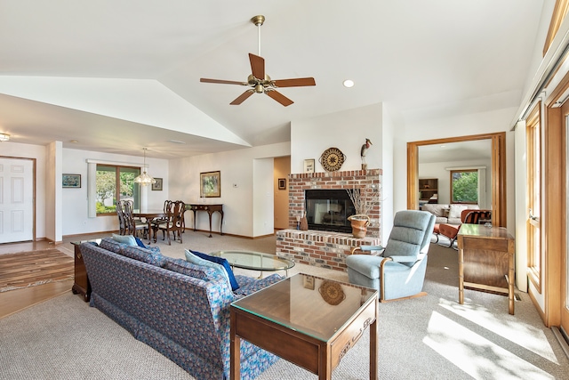 carpeted living room featuring a brick fireplace, ceiling fan, and vaulted ceiling