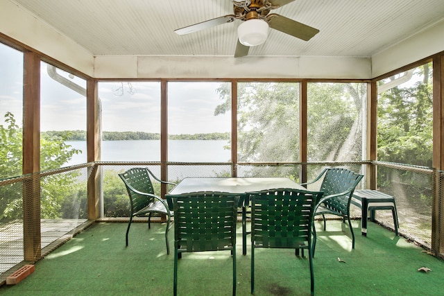 unfurnished sunroom with ceiling fan, a water view, and a jacuzzi