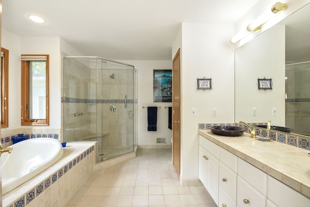 bathroom with tile patterned flooring, vanity, and independent shower and bath