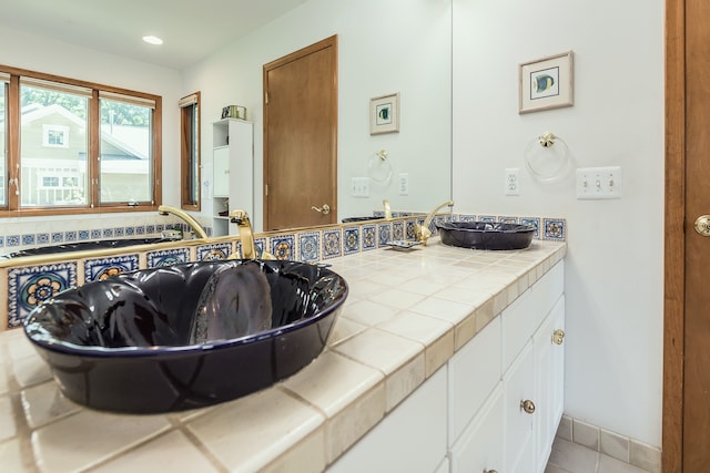 bathroom with tile patterned floors, vanity, and decorative backsplash