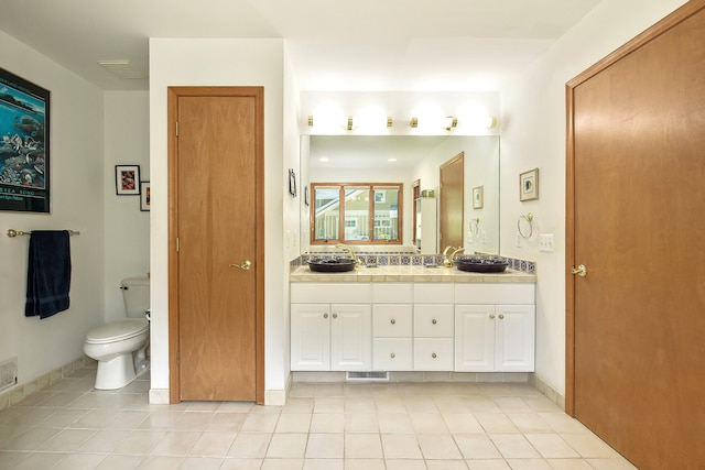 bathroom with tile patterned flooring, vanity, and toilet