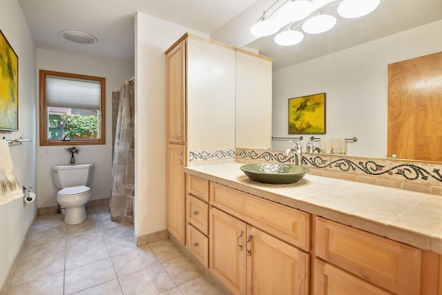 bathroom with tile patterned flooring, vanity, and toilet