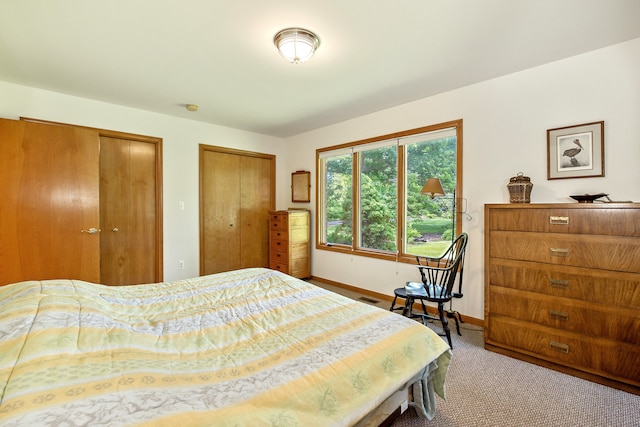 carpeted bedroom featuring two closets