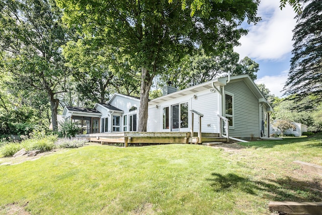 back of property with a lawn and a wooden deck