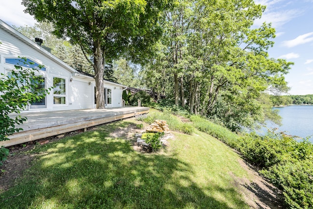 view of yard with a deck with water view