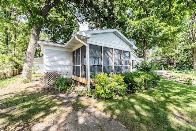 rear view of property with a sunroom and a yard